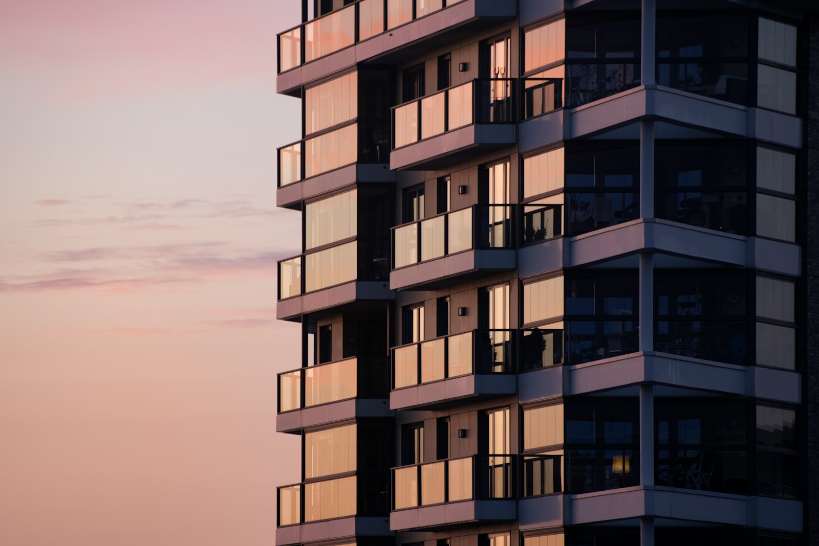 Modern multi-unit apartment building with glass balconies