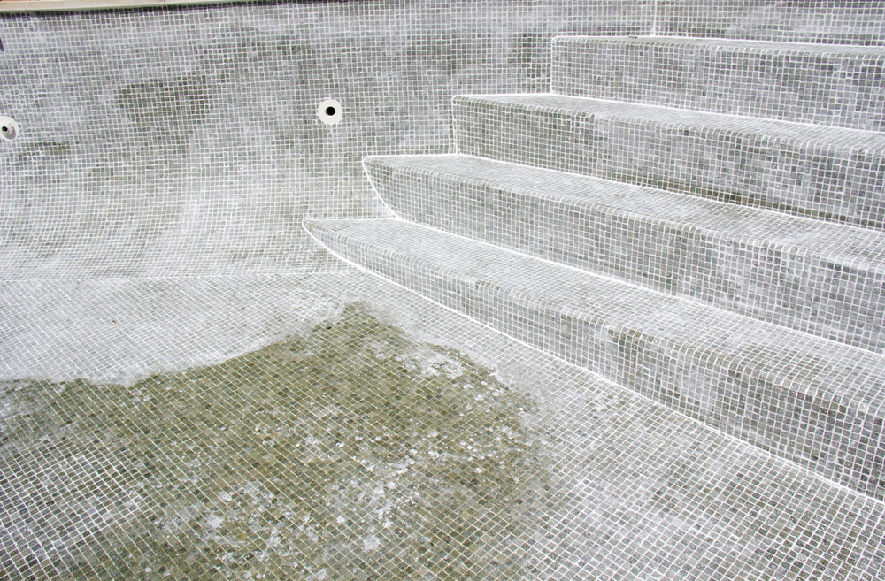 Drained swimming pool steps showing the tiled shell